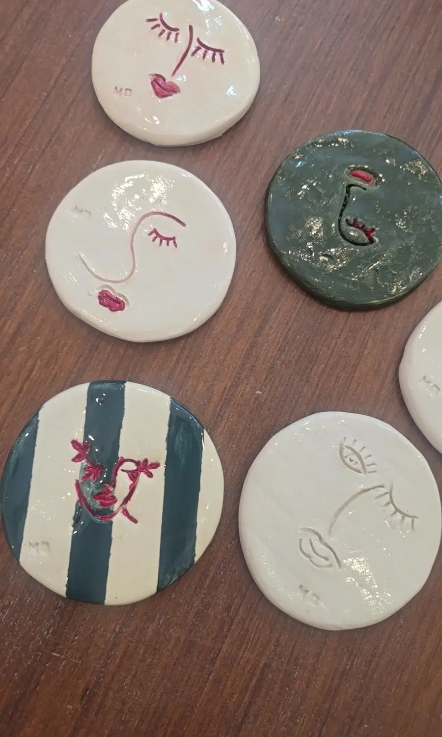 Cinq dessous-de-verre ronds peints de visages et de rayures