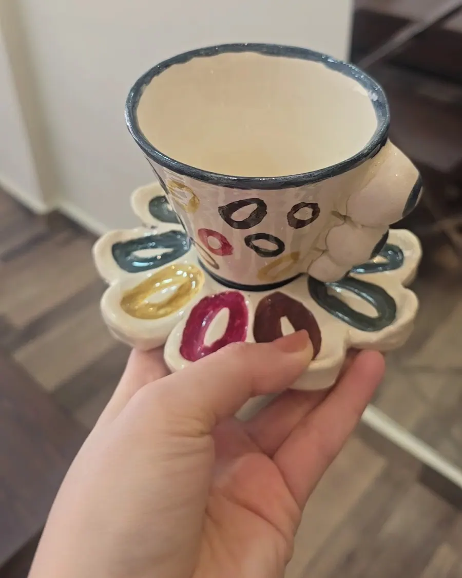 Tasse à anneaux colorés sur une soucoupe en forme de fleur